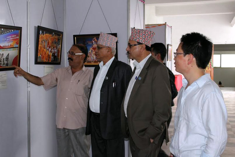Guests and visitors look onto photographs related to Nepal-China ties at an exhibition in Kathmandu on Monday, August 3, 2015. Photo: THT Online 