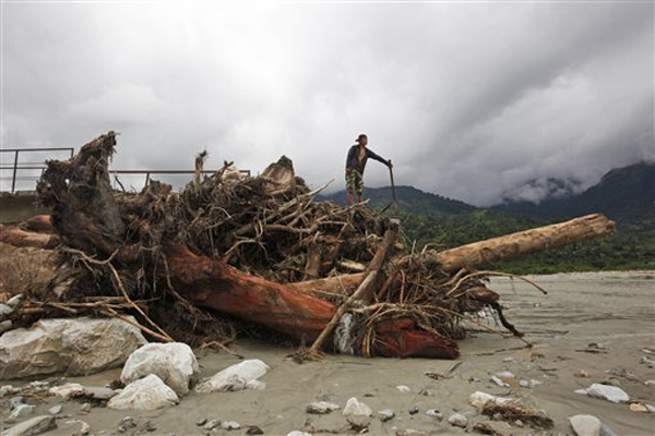 A man standing on a foot bridge destroyed by flood waters in Thulakhet, near Pokhara, on Friday. Landslides caused by heavy rains buried several houses in mountain villages on Thursday as bad weather hampered search for those missing in landslides. Photo:AP