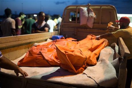 In this Thursday, Aug. 27, 2015 photo, bodies of migrants are taken from the scene of a capsized boat in Zuwara, Libya. AP