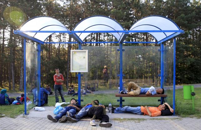 Migrants sleep at a bus stop after crossing into Hungary from the border with Serbia near Asotthalom, Hungary, August 30, 2015.  Photo: Reuters