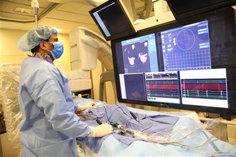 In this undated image provided on Saturday Aug. 29, 2015 by Mount Sinai Hospital in New York shows Dr Vivek Reddy as he checks the screen while doing a surgery to implant the new tiny wireless pacemaker at the Mount Sinai hospital in New York . Unlike traditional pacemakers u2014 which need a generator and wires and are implanted via surgery u2014 the new pacemaker is a wireless tiny tube that can be attached to the right side of the heart using a catheter inserted through the leg. Photo: AP