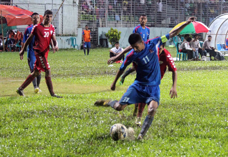 Nepal skipper Manish Karki (front) vies for the ball with a Afghanistan player during the first SAFF U-16 Championship match at the Sylhet District Stadium in Bangladesh on Friday. Photo: ANFA 