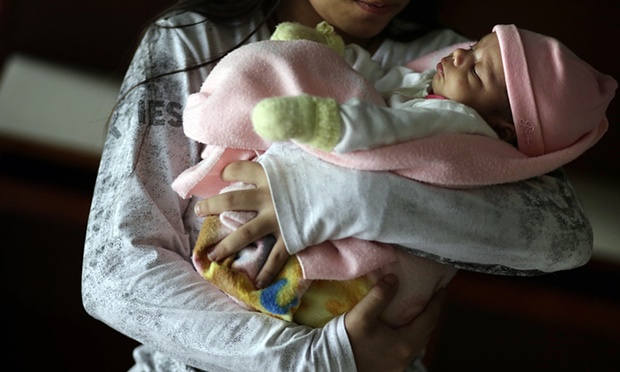 FILE - In this May 14, 2015 file photo, a 13-year-old girl holds her one-month-old baby at a shelter for troubled children in Ciudad del Este, Paraguay. Photo: AP