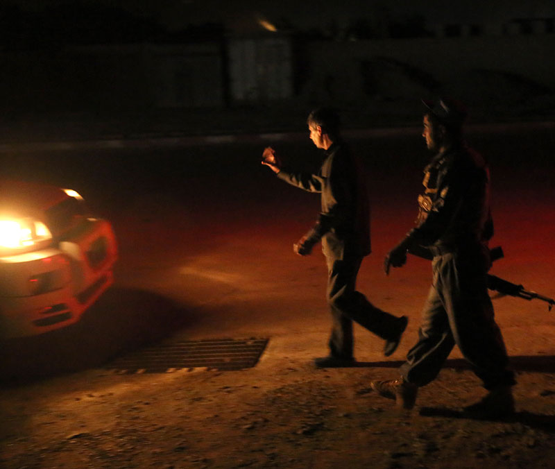 Afghanistan's security forces stop a vehicle near the site of an attack on a foreign camp integrity, north of Kabul, Afghanistan, Friday, Aug. 7, 2015. Two massive attacks in Kabul on Friday, one striking near a government and military complex in a residential area and the other a suicide bombing outside a police academy, killed at least 35 people. Photo: AP