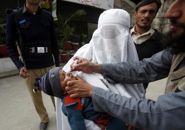 A girl receives polio vaccine drops at a government children's hospital in Peshawar, March 3, 2015. REUTERS/Fayaz Aziz/Files
