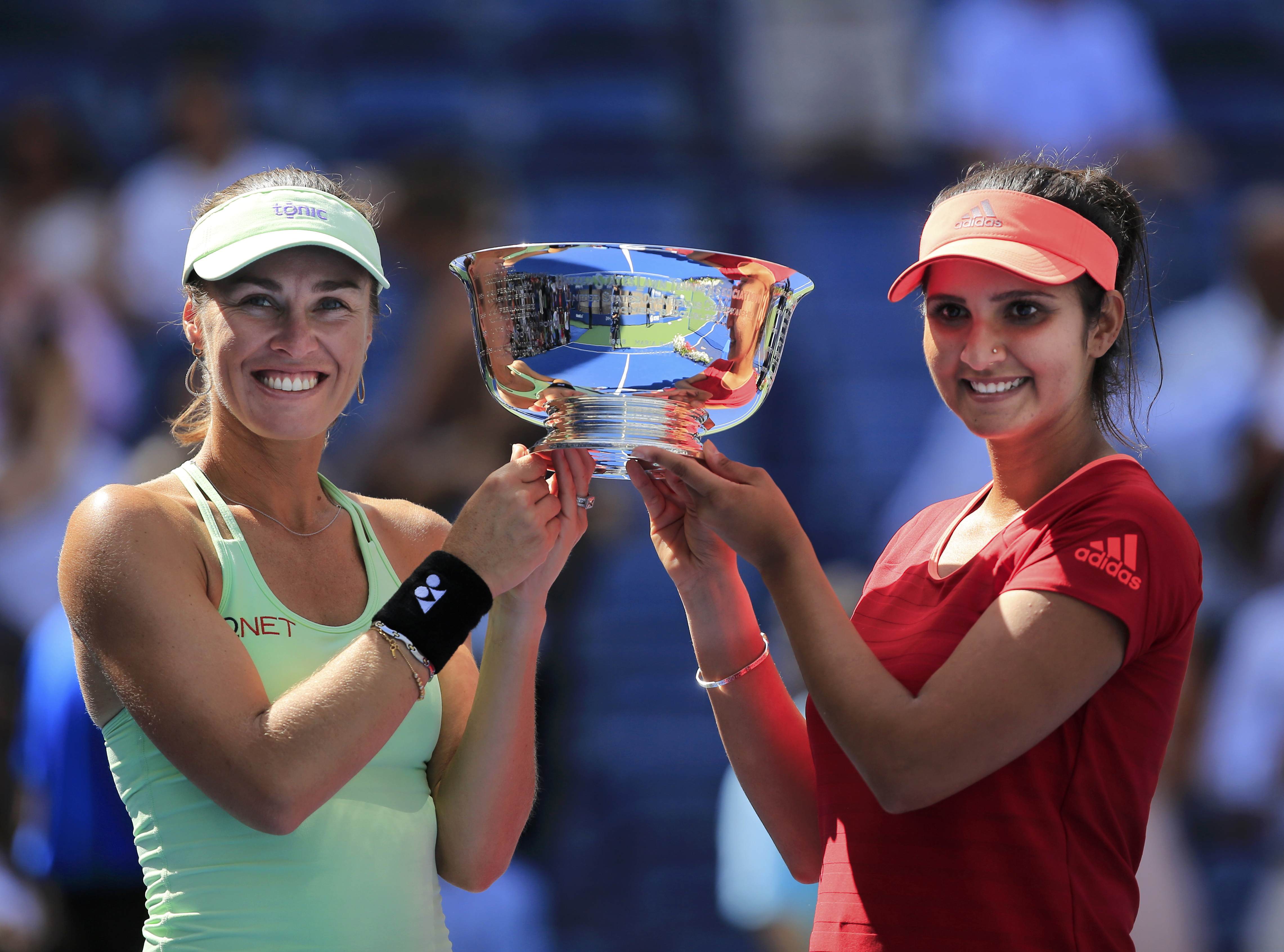 Martina Hingis of Switzerland (L) and Sania Mirza of India hold their trophy after defeating Casey Dellacqua of Australia and Yaroslava Shvedova of Kazakhstan in their women's doubles finals match at the U.S. Open Championships tennis tournament in New York, September 13, 2015.  REUTERS/Eduardo Munoz
