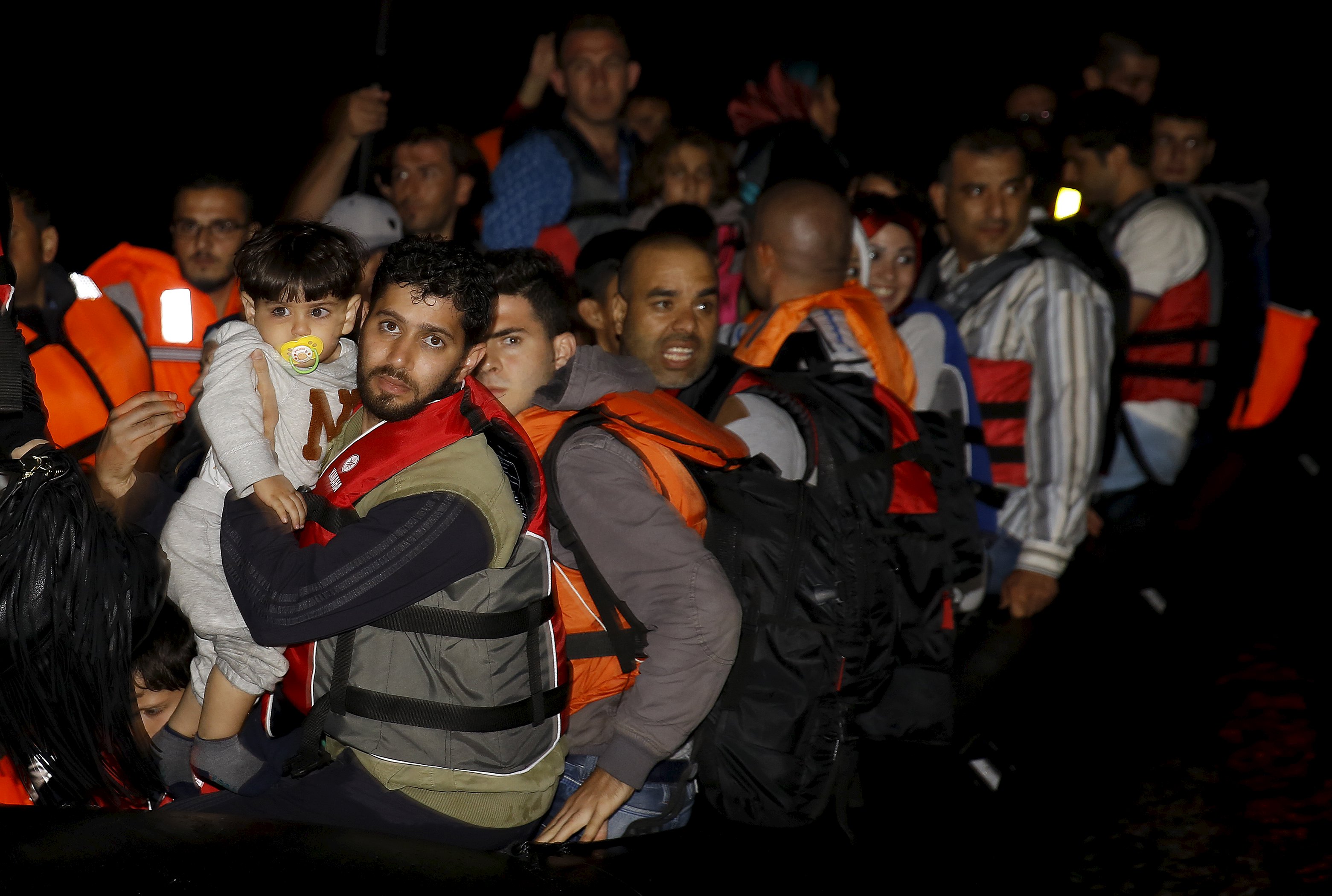 Syrian refugees arrive in an overcrowded dinghy at a beach on the Greek island of Lesbos after crossing a part of the Aegean Sea from Turkey to Lesbos September 25, 2015.  REUTERS/Yannis Behrakis