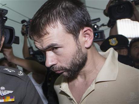 The suspect who was arrested at an apartment last week and found with evidence police said included bomb making equipment and stacks of fake passports is brought to court in the Min Buri district of Bangkok, Thailand, to extend his detention by police on Saturday, Sept. 5, 2015, after he was handed over from military custody on Friday. AP