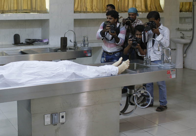 Journalists take photographs as the body of Italian citizen Cesare Tavella who was gunned down by unidentified assailants is kept at a hospital morgue in Dhaka, Bangladesh, Tuesday, Sept. 29, 2015. The Islamic State militant group claimed responsibility for gunning down the Italian citizen on the street in the diplomatic quarter of Bangladesh's capital, according to an intelligence group monitoring jihadist threats. (AP Photo/ A.M. Ahad)