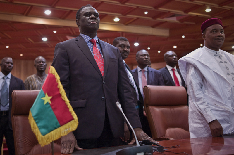 Burkina Faso's transitional president Michel Kafando, left, next to Niger's President, Mahamadou Issoufou, right, during a official handover ceremony  in Ouagadougou, Burkina Faso, Wednesday, Sept. 23, 2015. Amid cheers and the national anthem, Burkina Faso's interim president took charge of the country again Wednesday a week after a military general and his supporters overthrew him and his transitional government. Interim President Michel Kafando and Prime Minister Yacouba Isaac Zida marked their return to power in an official handover ceremony in Ouagadougou. (AP Photo)