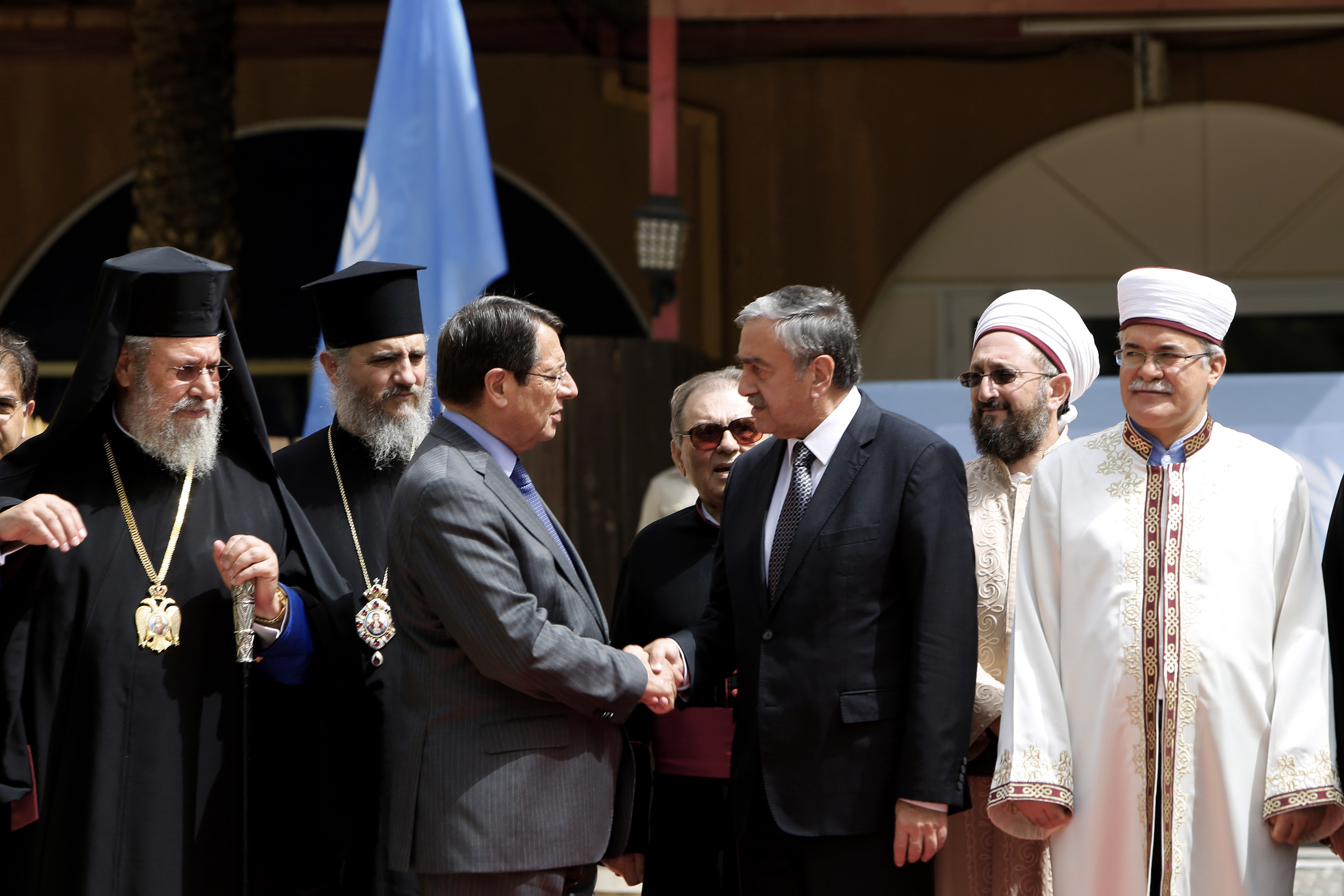 Cyprus' president Nicos Anastasiades, Turkish Cypriot leader Mustafa Akinci shake hands as the Greek Cypriot Orthodox Archbishop Chrysostomos II, left, and the Turkish Cypriot religious leader Mufti Yalip Atalay look on after a meeting at UN buffer zone at Ledra palace hotel in divided capital Nicosia, Cyprus, Thursday, Sept. 10, 2015. The heads of Cyprus' Christian and Muslim communities are meeting with the ethnically divided island's rival leaders to lend their support to ongoing reunification talks. Photo: AP