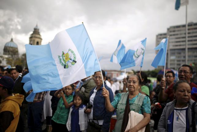 People carry Guatemalan flags while celebrating at constitution square as Guatemala's former president Otto Perez Molina attends a hearing at the Supreme Court of Justice, in Guatemala City, September 3, 2015. REUTERS/Jose Cabezas