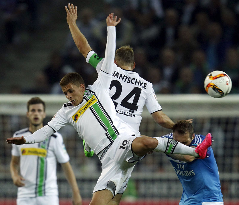 Hamburger SV's Pierre Michel Lasogga (R) and Borussia Moenchengladbach's Thorgan Hazard (L) and Tony Jantschke jump for a ball during their Bundesliga first division soccer match in Moenchengladbach, Germany September 11, 2015. Photo: Reuters