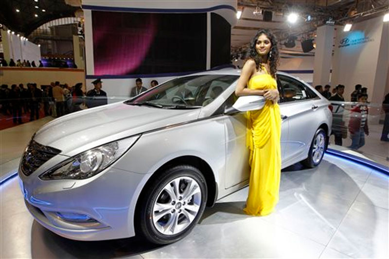 A model poses near the new version of Hyundai Sonata displayed at the Hyundai stall during Auto Expo in New Delhi, India on Jan 6, 2012.  Photo: AP