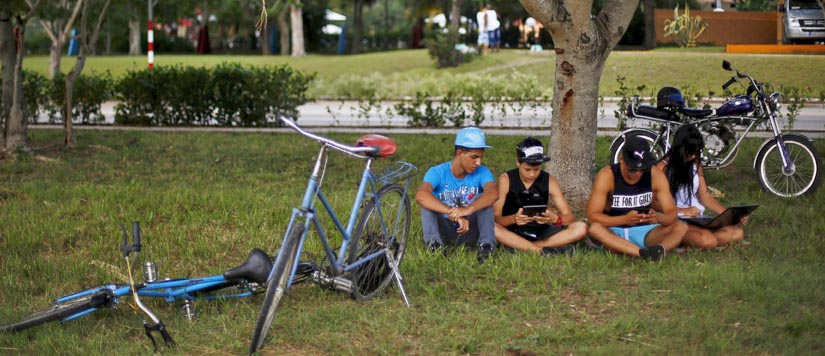 Youths use the internet via their mobile devices, with the aid of wi-fi from a nearby hotel, in Holguin, Cuba September 20, 2015. Photo: Reuters