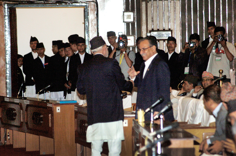 Sushil Koirala and Pushpa Kamal Dahal greeting each other as the CA puts amendment proposals to vote on Sunday. Photo: THT