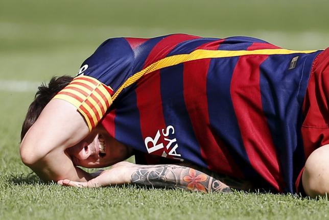 Barcelona's Lionel Messi grimaces as he lies on the pitch after injuring his left knee during their Spanish first division soccer match against Las Palmas at Camp Nou stadium in Barcelona, Spain, September 26, 2015. Photo: Reuters