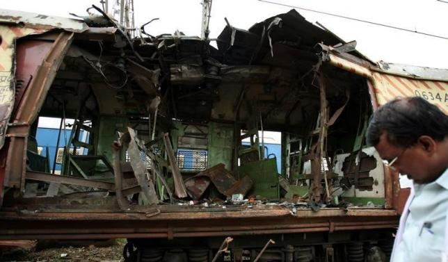 A forensic officer examines a damaged railway train compartment hit by bomb blast in Mumbai July 12, 2006. REUTERS/Punit Paranjpe/Files