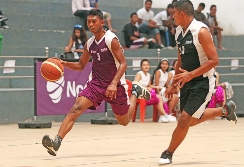 Suraj Khadgi (left) of Prime College drives the ball against Jenish Lama of LRI College during their Ncell U-18 Inter-college Basketball Tournament at the Nepali Army Sports Complex in Lalitpur on Thursday. Prime won the match 59-54. Photo:  Udipt Singh Chhetry