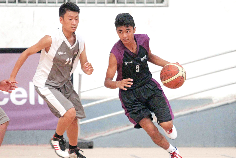 Himal Khatri (right) of GEMS drives the ball against Ritiz Rai of White House during their Ncell U-18 Inter-college Basketball Tournament match in Lalitpur on Tuesday. Photo: THT