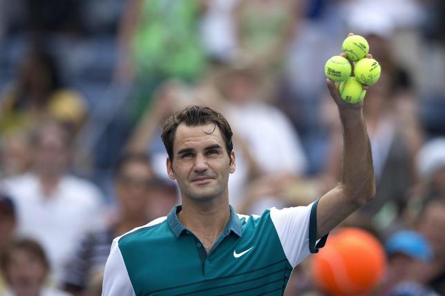 Roger Federer of Switzerland holds a handful of tennis balls before hitting them towards fans after defeating Leonardo Mayer of Argentina in their first round match at the U.S. Open Championships tennis tournament in New York, September 1, 2015.    REUTERS/Carlo Allegri