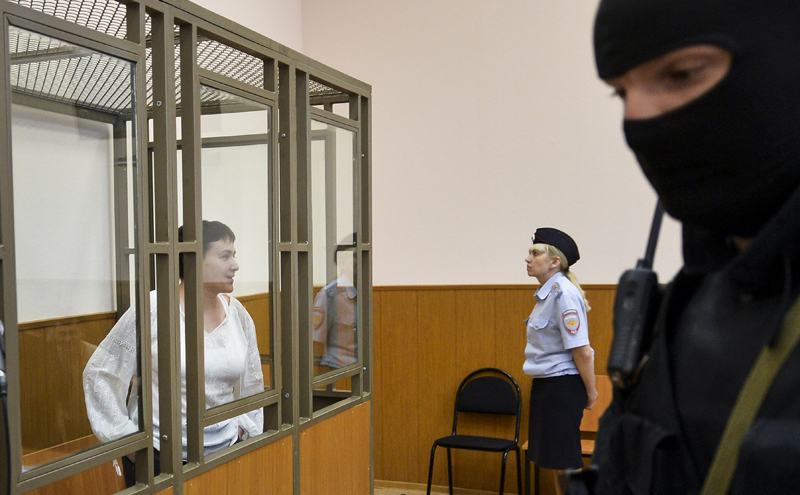 Ukrainian jailed military officer Nadezhda Savchenko, left, stands in a cage during a court hearing in a town of Donetsk, Rostov-on-Don region, Russia, on Tuesday, Sept. 29, 2015. The Russian court has begun hearing the high-profile case against Ukrainian officer Nadezhda Savchenko, who is charged in the deaths of two Russian journalists in eastern Ukraine. Russian investigators allege that Savchenko, who served in a volunteer battalion fighting with government troops against Russia-backed rebels, provided the coordinates for a mortar attack that killed the journalists in June 2014. (AP Photo)