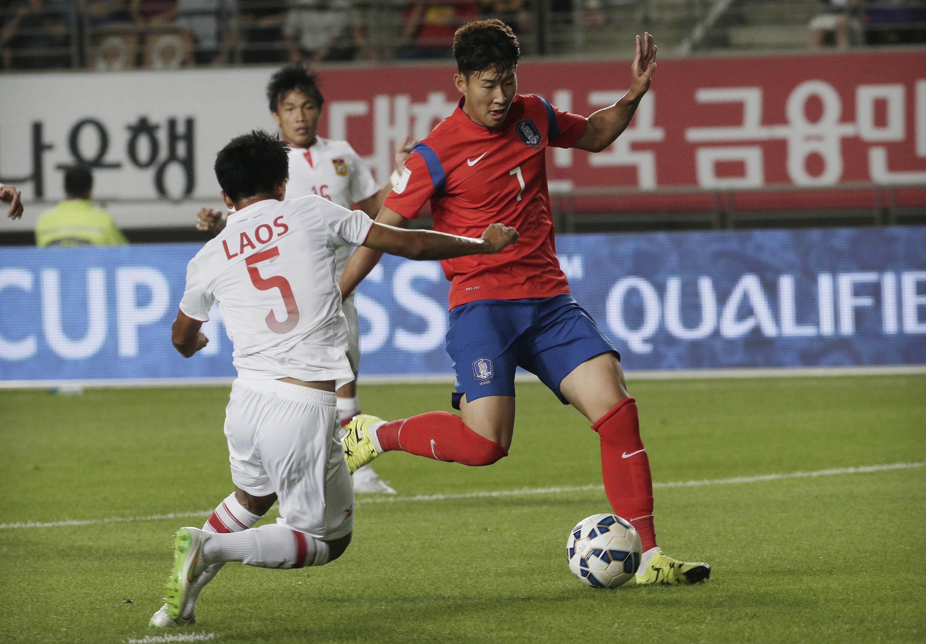 South Korea's Son Heung-min, right, scores his first goal as Laos's Pinkeo Khamla tries to block it during their Asian zone Group G qualifying soccer match for the 2018 World Cup at  Hwaseong Sports Complex Main Stadium in Hwaseong, South Korea, Thursday, Sept. 3, 2015. South Korea won 8-0.(AP Photo/Ahn Young-joon)