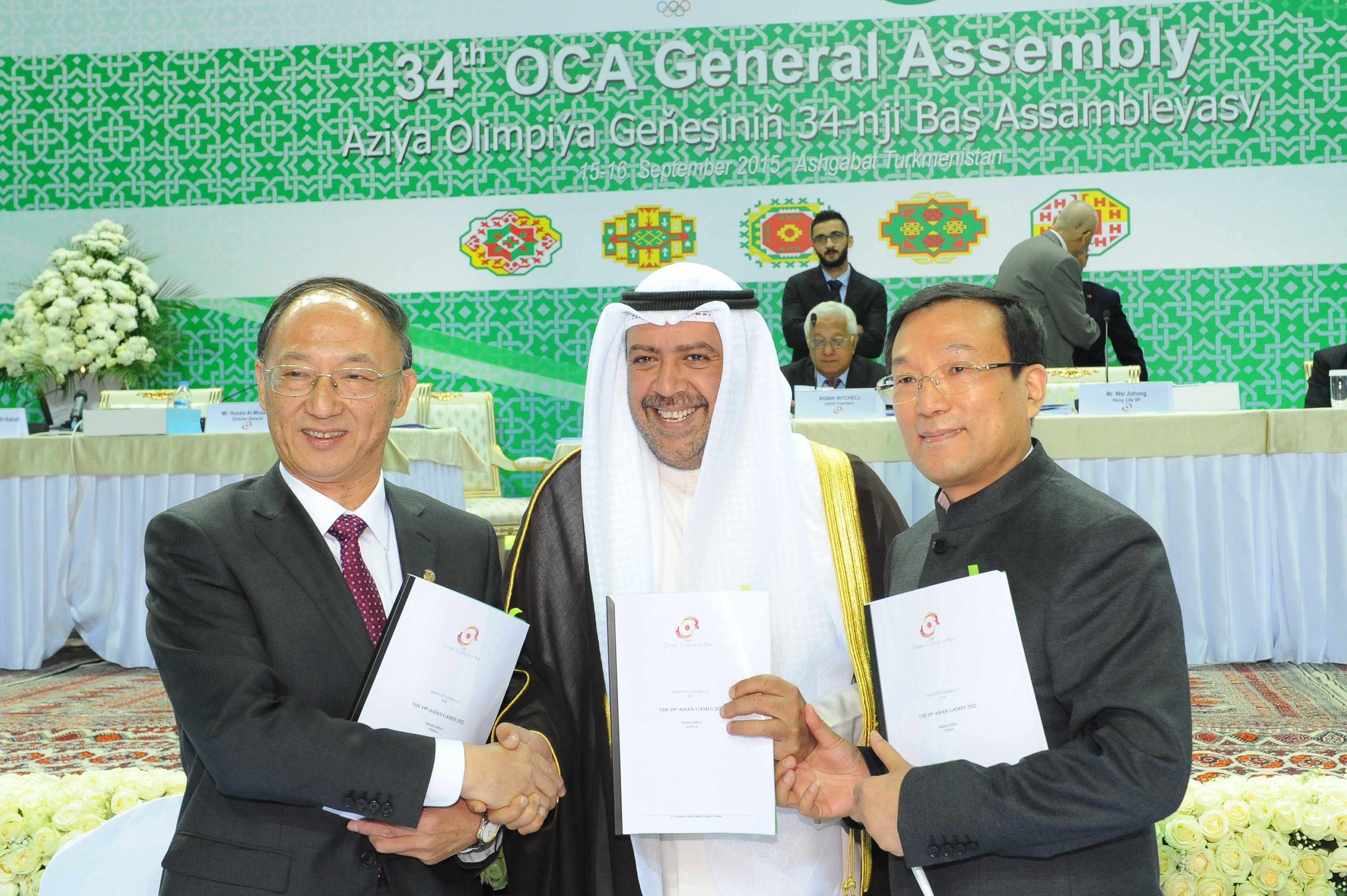 From left, Minister of Sport of China Liu Peng, President of the Olympic Council of Asia Shiekh Ahmad Al-Fahad Al-Sabah and Mayor of Hangzhou Zhang Hogming shake hands after a signing ceremony in Ashgabat, Turkmenistan, Wednesday, Sept. 16, 2015. The Chinese city of Hangzhou has been confirmed as the host of the 2022 Asian Games after standing as the only candidate. The Olympic Council of Asia signed a contract with officials from the coastal city of almost 9 million people during meetings in Turkmenistan on Wednesday. (AP Photo/ Alexander Vershinin)