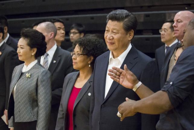Chinese President Xi Jinping (front 2nd R) listens as Lawyer Milloy (R), a former NFL player and Lincoln High School alumnus, explains American football while Chinese First Lady Peng Liyuan (L) and Tacoma mayor Marilyn Strickland (2nd L) watch a football demonstration during a visit to Lincoln High School in Tacoma, Washington, September 23, 2015.   REUTERS/David Ryder