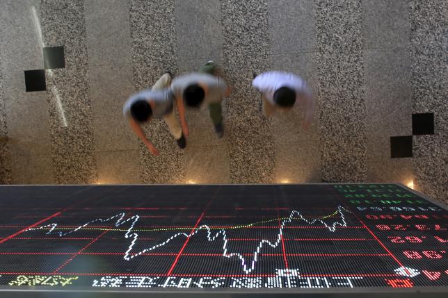People walk under an electronic board showing stock information at the Shanghai Stock Exchange in Lujiazui Financial Area before the visit of Britain's Chancellor of the Exchequer George Osborne in Shanghai, China, September 22, 2015. Photo: Reuters