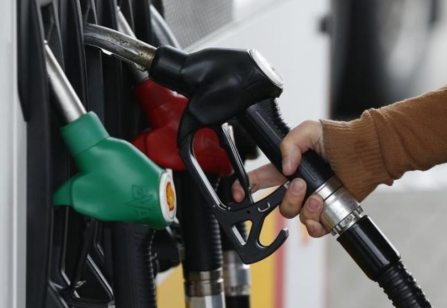 A customer prepares to fill the tank of her car at a fuel station in Sint Pieters Leeuw December 5, 2014.   Photo: Reuters 