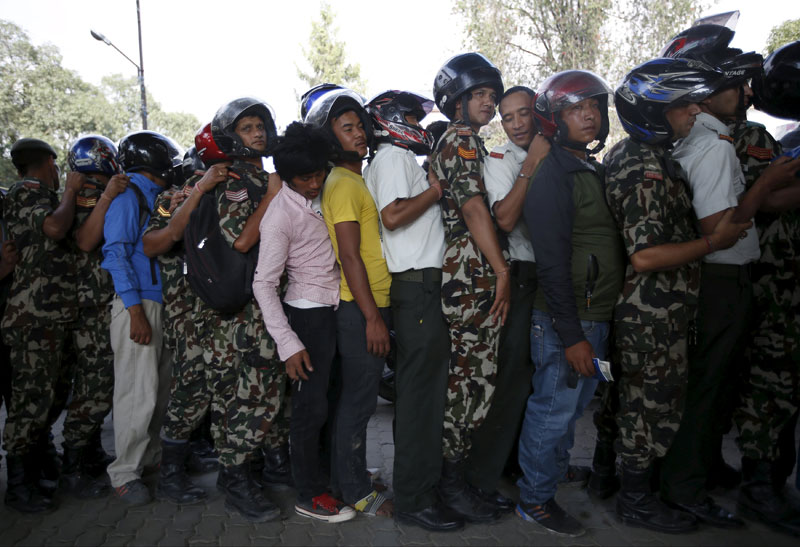 Motorists wait in a queue to fill petrol for their vehicle at a petrol station in Kathmandu, Nepal September 28, 2015. Photo: Reuters
