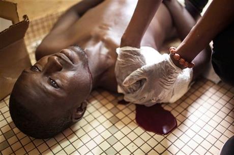A protester who was shot during clashes is treated in a hospital in Ouagadougou, Burkina Faso, Thursday, Sept. 17, 2015. The protester later died. AP