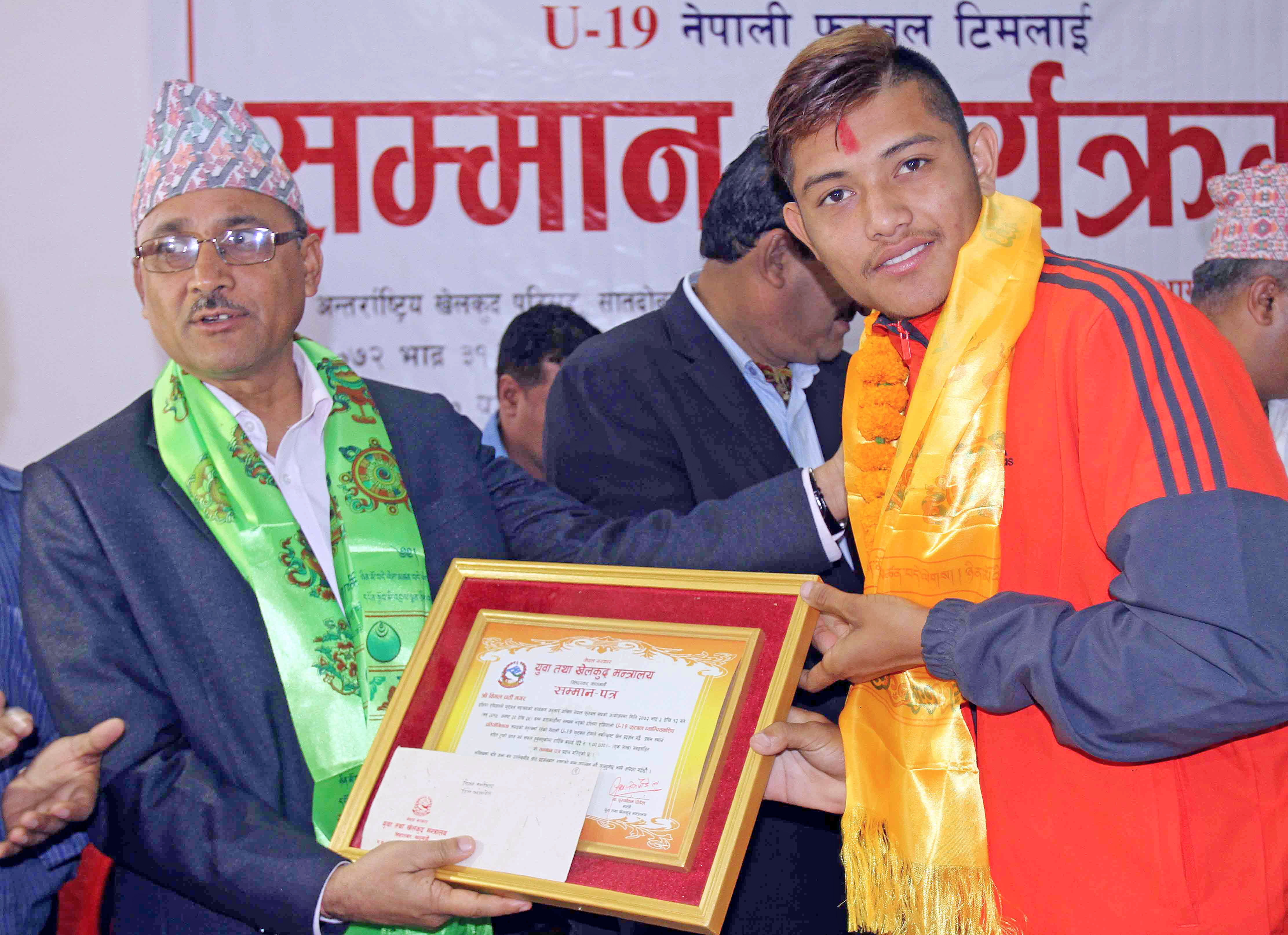 Bimal Gharti Magar skipper of U-19 national football team winner of the  1st SAFF U-19 Championship receives letter of felicitation and cash prize form Purushottam Poudel Minister of Youth and Sports at International Sports Complex in Lalitpur on Thursday.  (Credit Image: Udipt Singh Chhetry)