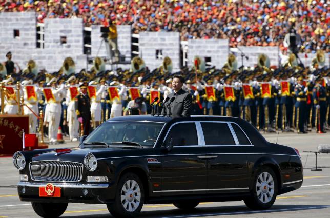 Chinese President Xi Jinping stands in a car on his way to review the army as military band members play next to him, at the beginning of the military parade marking the 70th anniversary of the end of World War Two, in Beijing, China, September 3, 2015. Photo: REUTERS