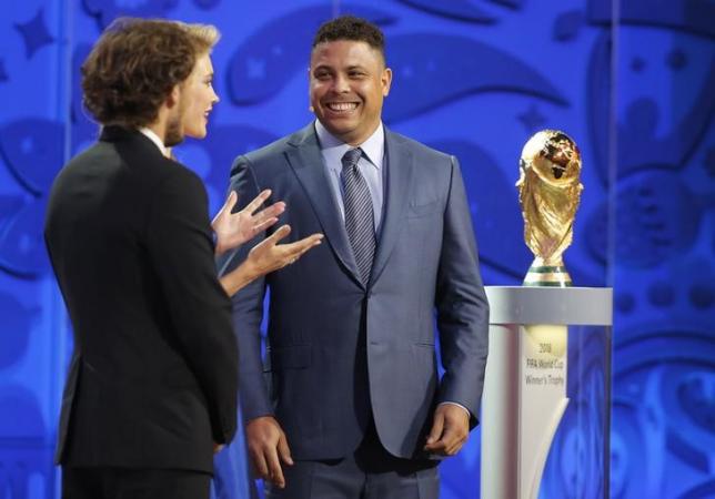Former soccer player Ronaldo of Brazil is introduced as draw assistant by presenters Natalia Vodianova and Dmitry Shepelev (R-L) during the preliminary draw for the 2018 FIFA World Cup at Konstantin Palace in St. Petersburg, Russia July 25, 2015.  REUTERS/Maxim Shemetov