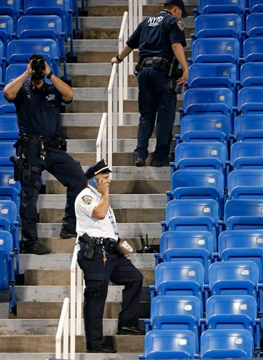 Police officers investigate the southwest corner of Louis Armstrong Stadium after a drone flew over the court, buzzing the players during a match between Flavia Pennetta, of Italy, and Monica Niculescu, of Romania, during the second round of the U.S. Open tennis tournament in New York, Thursday, Sept. 3, 2015. photo: AP