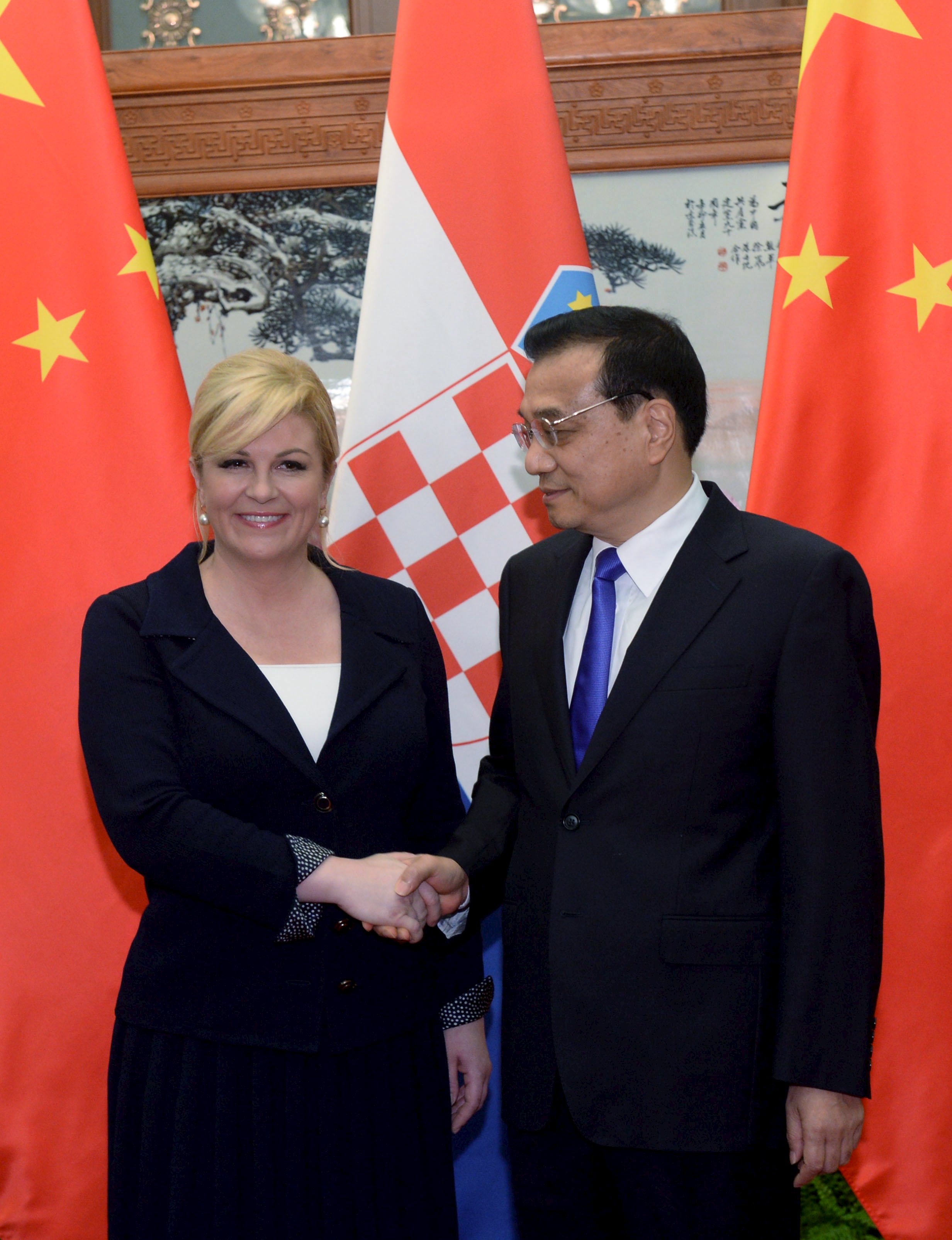 Chinese Premier Li Keqiang (R) shakes hands with Croatian President Kolinda Grabar-Kitarovic before their meeting at the Great Hall of the People in Beijing, China, October 15, 2015. REUTERS/Parker Song/Pool