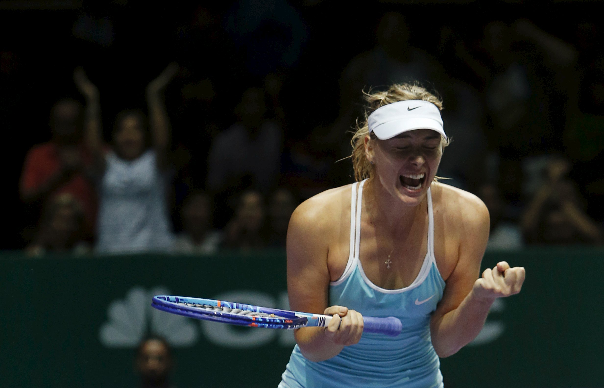 Maria Sharapova of Russia celebrates defeating Simona Halep of Romania during their women's singles tennis match of the WTA Finals at the Singapore Indoor Stadium October 27, 2015. Photo: Reuters