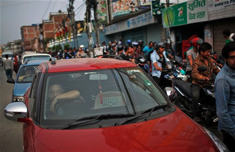 A man sits inside his car as he waits for his turn to fill fuel at a gas station in Kathmandu, Nepal, Tuesday, Oct. 13, 2015. Photo: AP