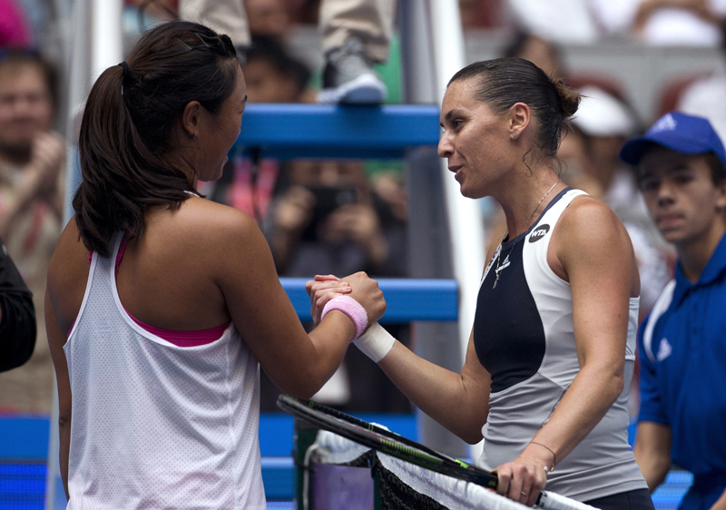 Flavia Pennetta of Italy, right, shakes hand with Han Xinyun of China after winning their match of the China Open tennis tournament at the National Tennis Stadium in Beijing, Sunday, Oct. 4, 2015. (AP Photo/Andy Wong)