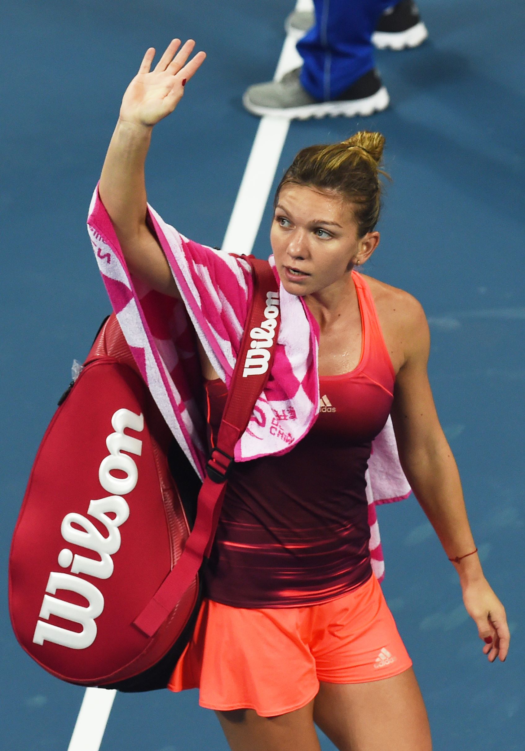 Simona Halep of Romania waves to the crowd after retiring from her first round women's singles match against Lara Arruabarrena of Spain at the China Open tennis tournament in Beijing on October 4, 2015. AFP PHOTO / GREG BAKER