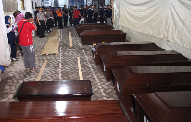 Coffins containing the bodies of the victims of DHC-6 Twin Otter plane owned by the airline Aviastar Mandiri that crashed into a mountainous area on Sulawesi Island are laid at a hospital in Makassar, Indonesia, Tuesday, Oct. 6, 2015. Indonesian rescuers on Monday found the wreckage of the small plane carrying 10 people that went missing on a domestic flight four days ago. (AP Photo)