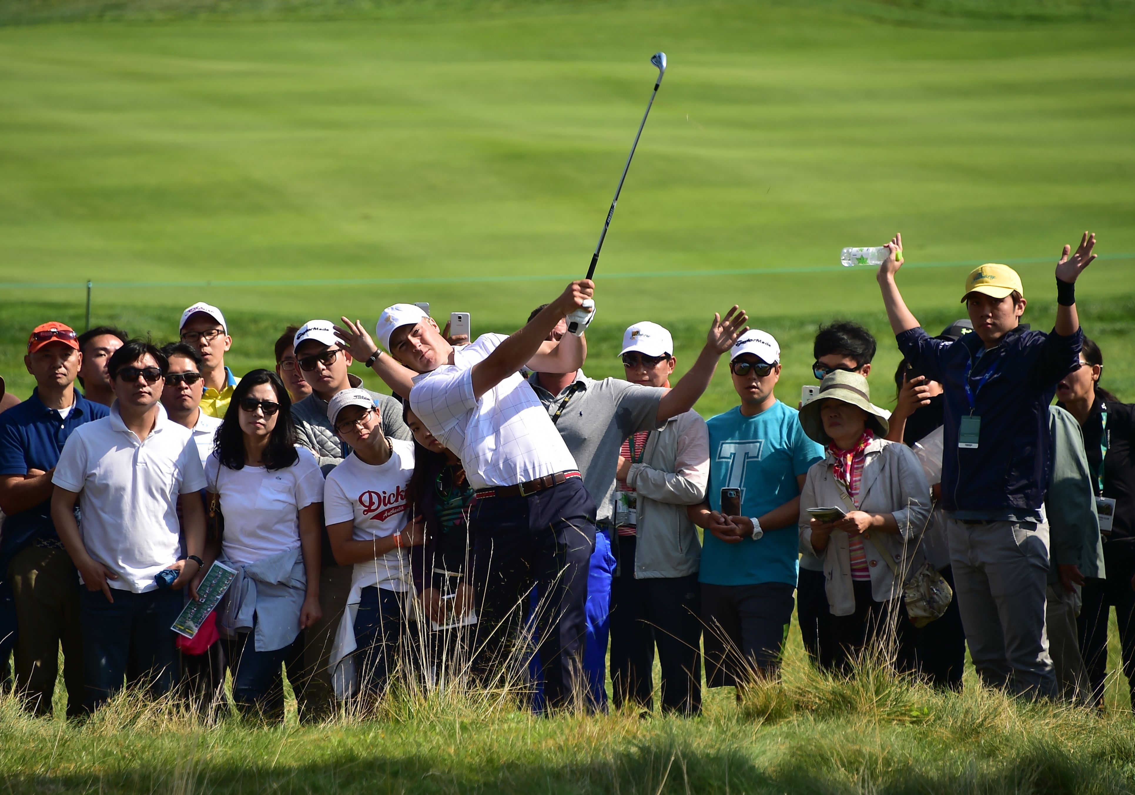 TOPSHOTSnJordan Spieth (C) of the US hits a shot from the rough on the 1st hole during the first round of foursome matches at the 2015 Presidents Cup at the Jack Nicklaus Golf Club in Incheon, west of Seoul, on October 8, 2015.     AFP PHOTO / JUNG YEON-JE     nRESTRICTED TO EDITORIAL USE - STRICTLY NO COMMERCIAL USE