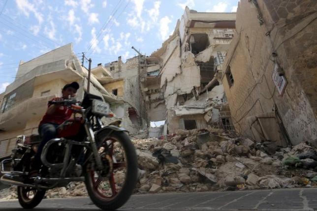 A boy rides a motorcycle through a damaged street in Old Aleppo, Syria September 5, 2015. REUTERS/Abdalrhman Ismail/Files