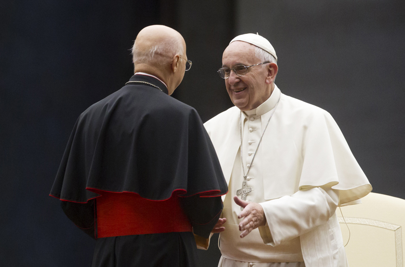 Pope Francis greets Italian Episcopal conference (CEI) president Cardinal Angelo Bagnasco, left, during a vigil ahead of the opening of the Synod of bishops, in St. Peter's Square at the Vatican, Saturday, Oct. 3, 2015. (AP Photo/Riccardo De Luca)