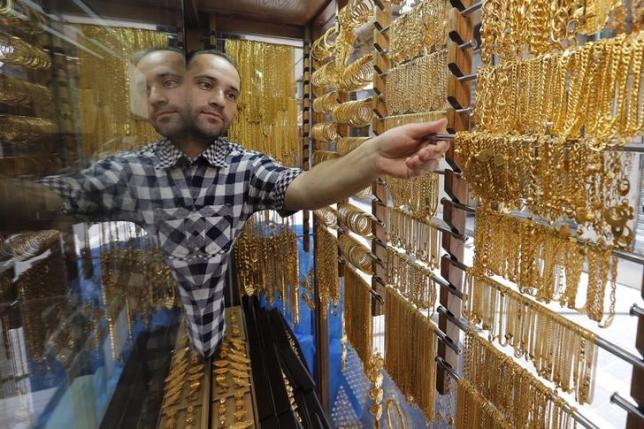 A Jordanian goldsmith places gold chains for display at his jewellery shop in Amman, Jordan July 27, 2015. REUTERS/Muhammad Hamed