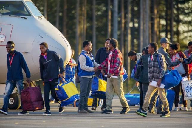 Eritrean migrants arrive at Lulea airport, Kallax in northern Sweden, with an Italian police aircraft that took off from Rome's Ciampino airport earlier on Friday, October 9, 2015. REUTERS/Robert Nyholm/TT News Agency