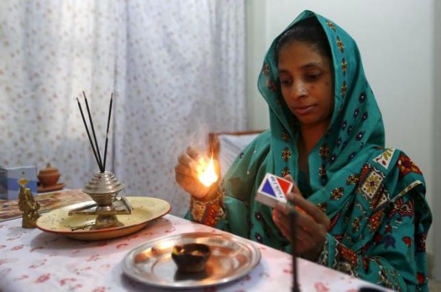 Geeta lights a match as she prepares to pray at the Bilquis Edhi Foundation in Karachi, Pakistan, August 6, 2015.  Photo: REUTERS
