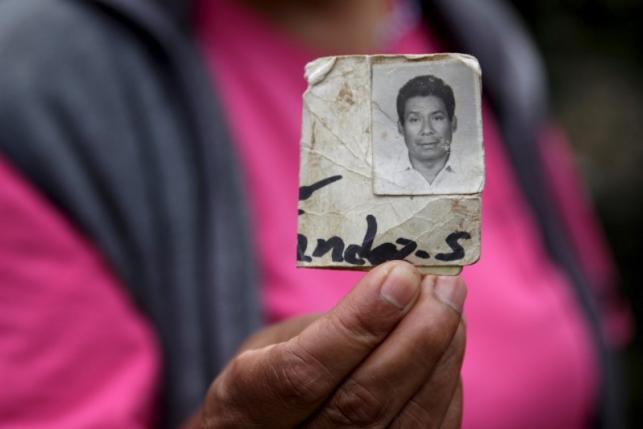 A woman shows the photograph of a missing relative at the site of a mudslide in Santa Catarina Pinula, on the outskirts of Guatemala City, October 3, 2015. Photo: REUTERS